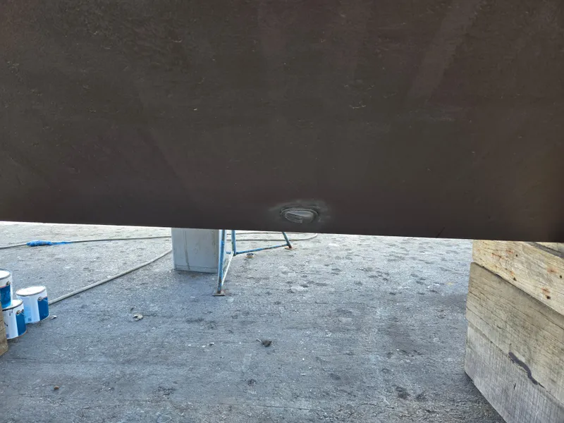 Slide: The Image of Bottom view of a 1986 Hatteras 53 Extended Deckhouse hull with visible dent. - 33