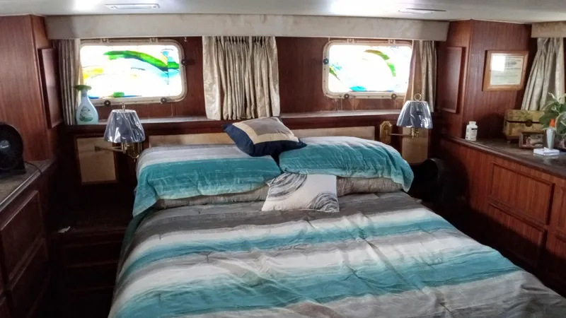 Slide: The Image of Luxurious bedroom in 1986 Hatteras 53 Extended Deckhouse Motor Yacht with large bed and porthole windows. - 7