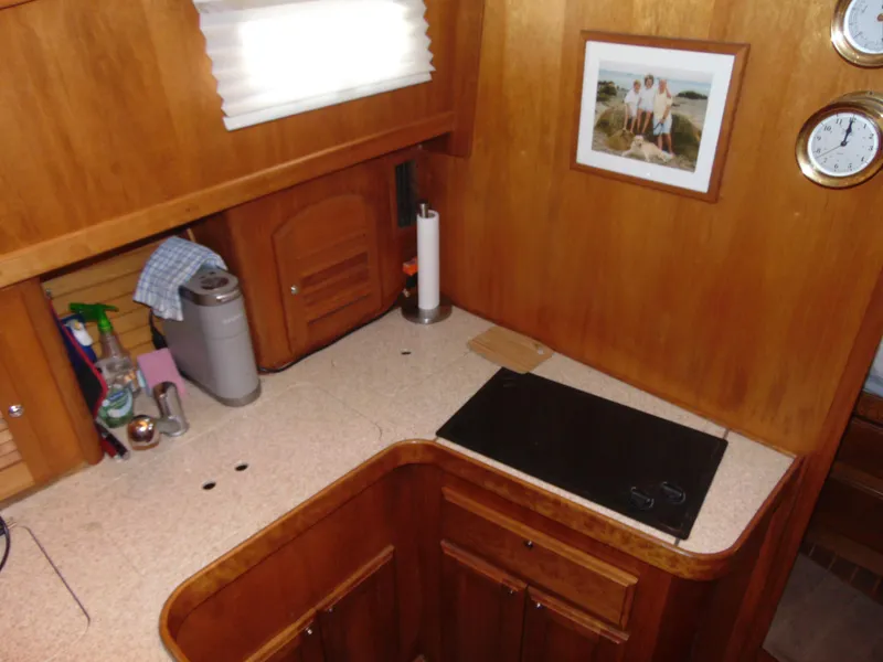 Slide: The Image of 2004 Sabre 36 Flybridge kitchen with wooden cabinets, countertop, and appliances. - 11
