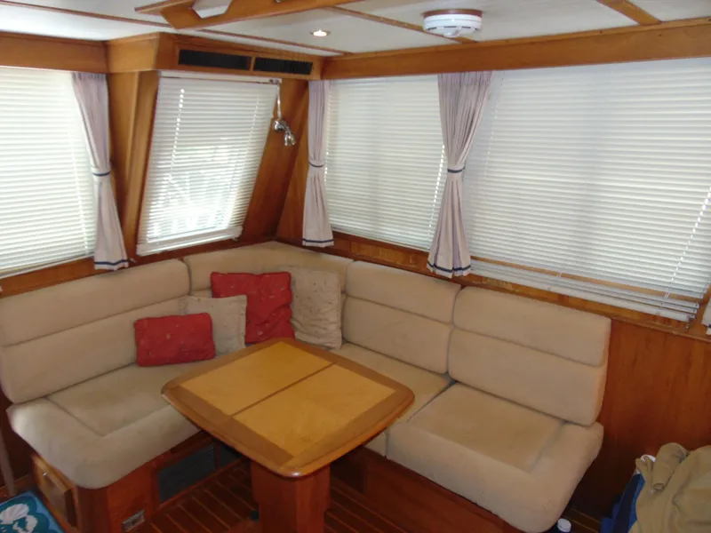 Slide: The Image of Interior of 2004 Sabre 36 Flybridge with beige seating and wooden table. - 8