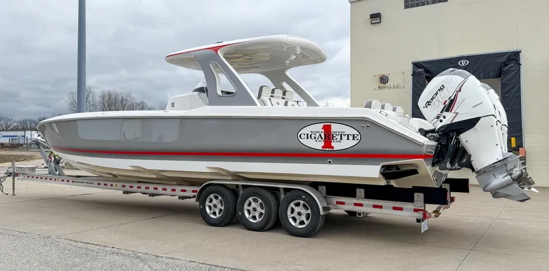 Slide: The Image of 2018 Cigarette 39 GTS boat on trailer, gray and white with red accents. - 2