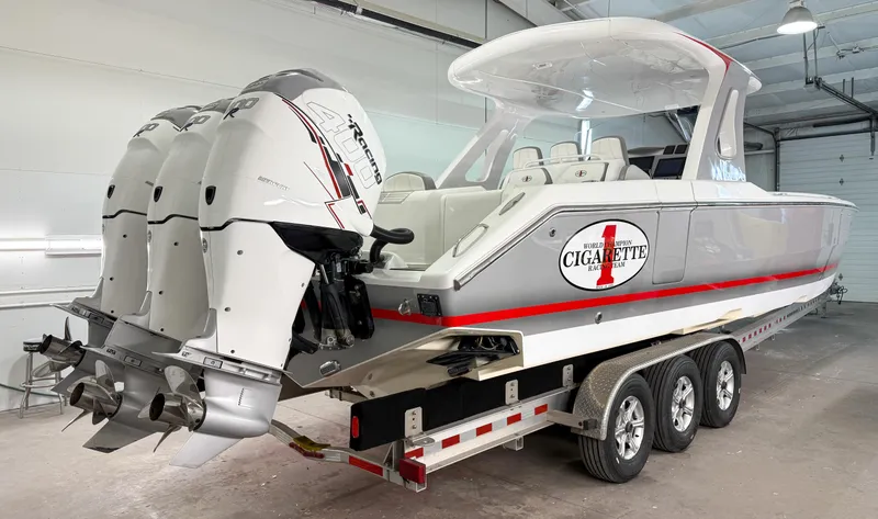 Slide: The Image of 2018 Cigarette 39 GTS boat on trailer in garage, featuring triple outboard engines. - 5