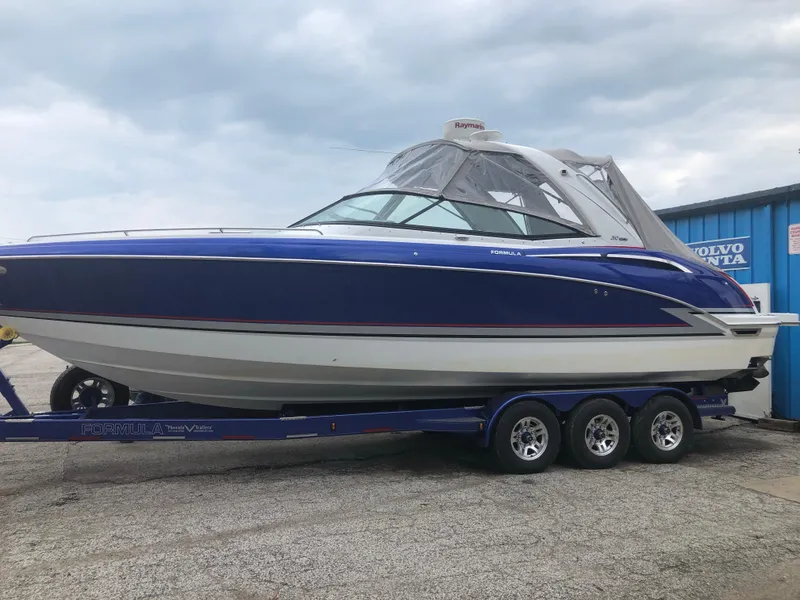 Slide: The Image of 2015 Formula 310 Sun Sport boat on a trailer, blue and white exterior. - 3