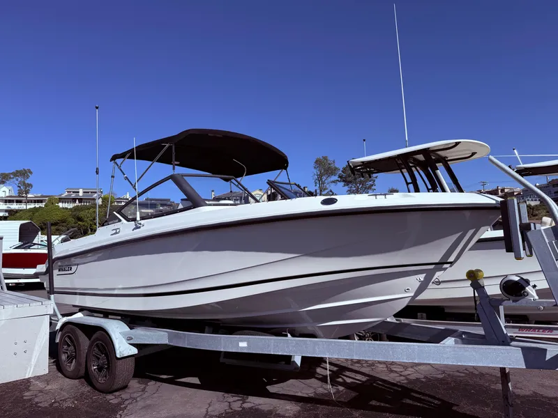 The Image of 2025 Boston Whaler 210 Vantage boat on trailer under clear blue sky. - 0
