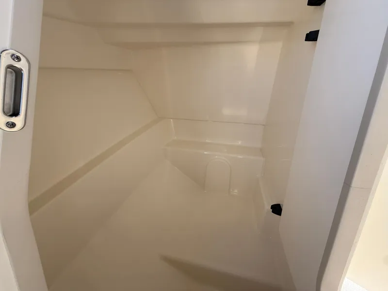 Slide: The Image of Interior cabin of 2025 Boston Whaler 210 Vantage boat, featuring sleek white design. - 11