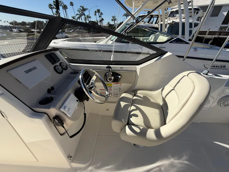 Slide: The Image of 2025 Boston Whaler 210 Vantage boat interior with steering wheel and comfortable seating. - 12