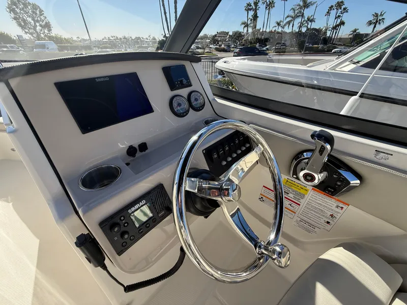 Slide: The Image of 2025 Boston Whaler 210 Vantage helm with steering wheel and control panel. - 14