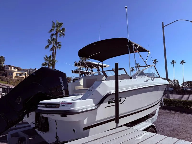 Slide: The Image of 2025 Boston Whaler 210 Vantage boat on trailer, palm trees in background. - 3