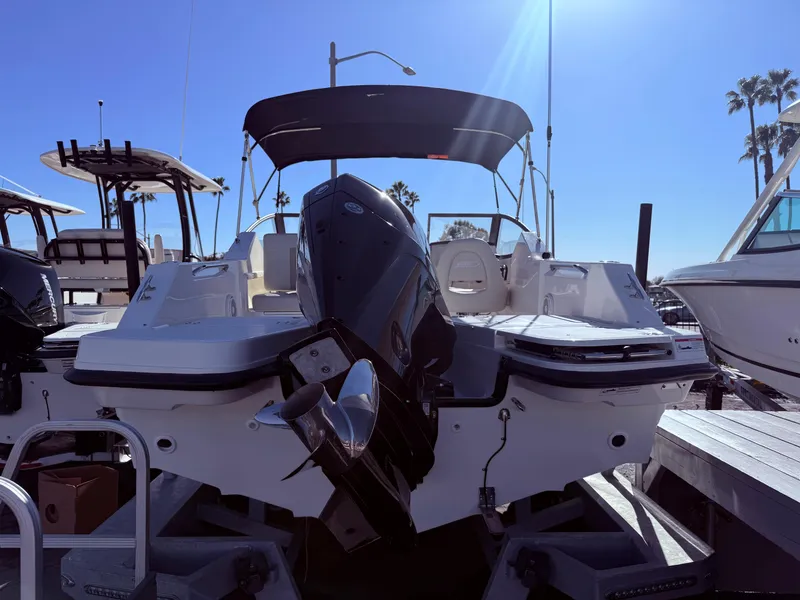 Slide: The Image of 2025 Boston Whaler 210 Vantage boat with outboard motor, docked under clear blue sky. - 4