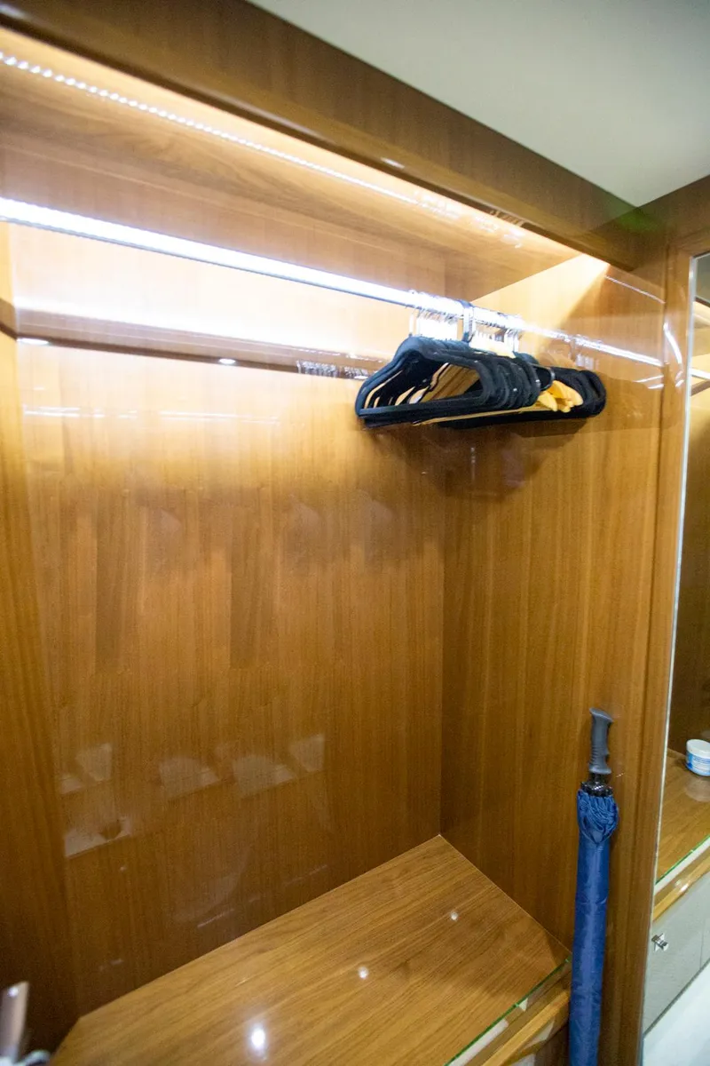 Slide: The Image of Wooden closet interior on 2011 Princess 85 Motor Yacht with hangers and umbrella. - 18