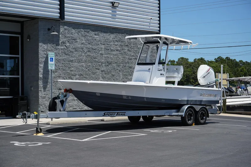 The Image of 2025 Blazer 2550 GTS boat on a Sport Trail trailer in a parking lot. - 1