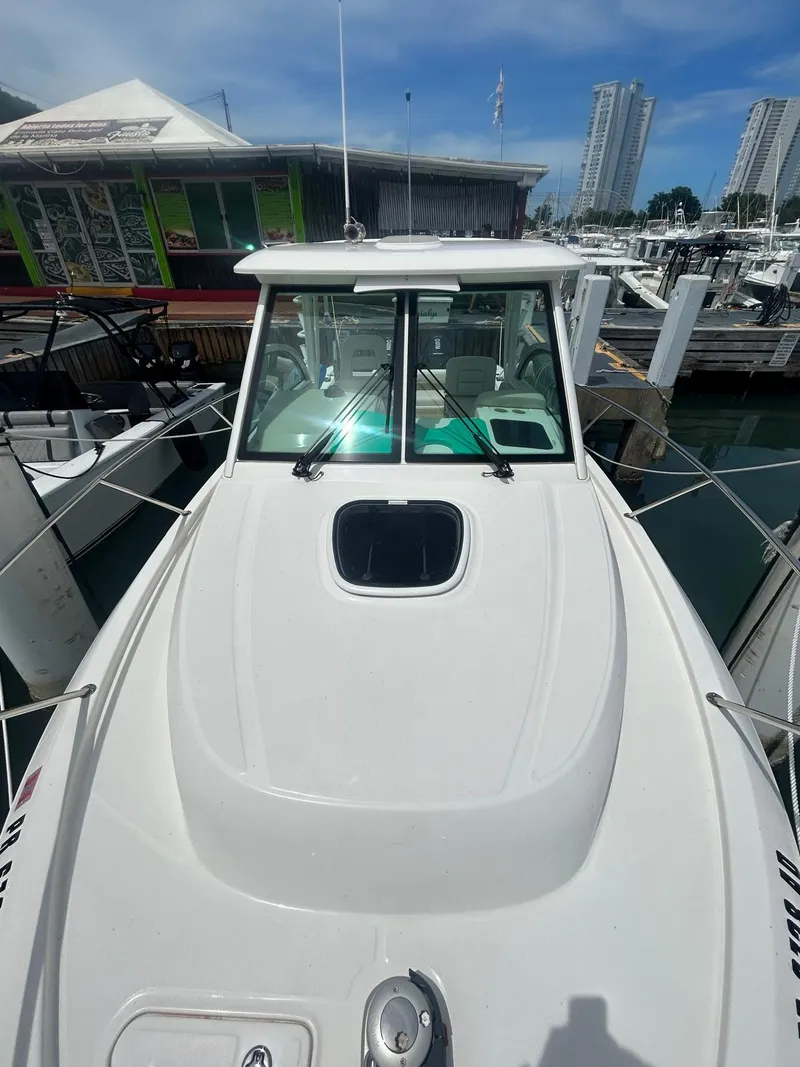 The Image of 2023 Boston Whaler 285 Conquest boat docked at marina with cityscape background. - 0