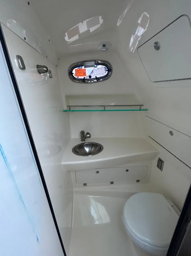 Slide: The Image of 2023 Boston Whaler 285 Conquest boat bathroom with sink, toilet, and storage. - 6