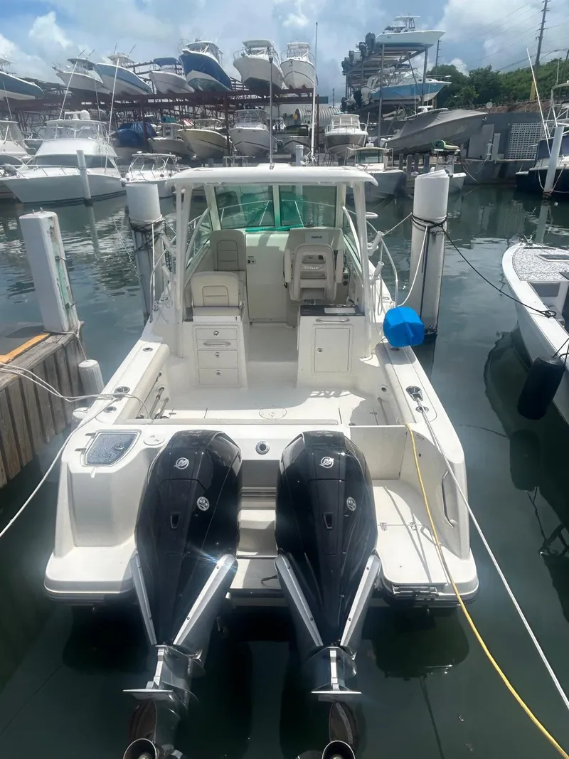 Slide: The Image of 2023 Boston Whaler 285 Conquest docked, featuring dual outboard engines. - 8