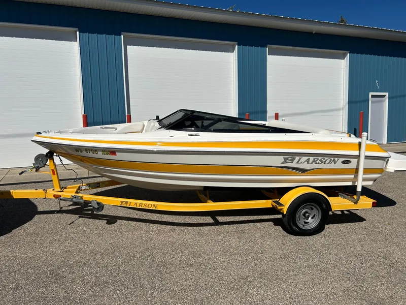 Slide: The Image of 2007 Larson 180SEI LX boat on yellow trailer, parked outside blue garage. - 15
