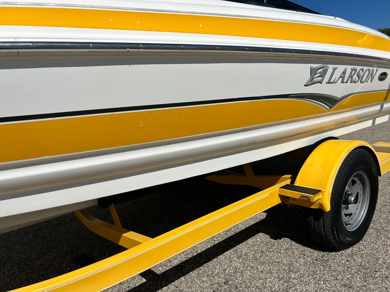 Slide: The Image of 2007 Larson 180SEI LX boat with yellow and white design on a matching trailer. - 16
