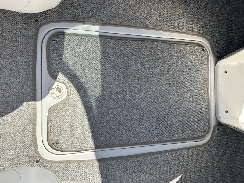 Slide: The Image of 2007 Larson 180SEI LX boat floor compartment with gray carpet. - 21