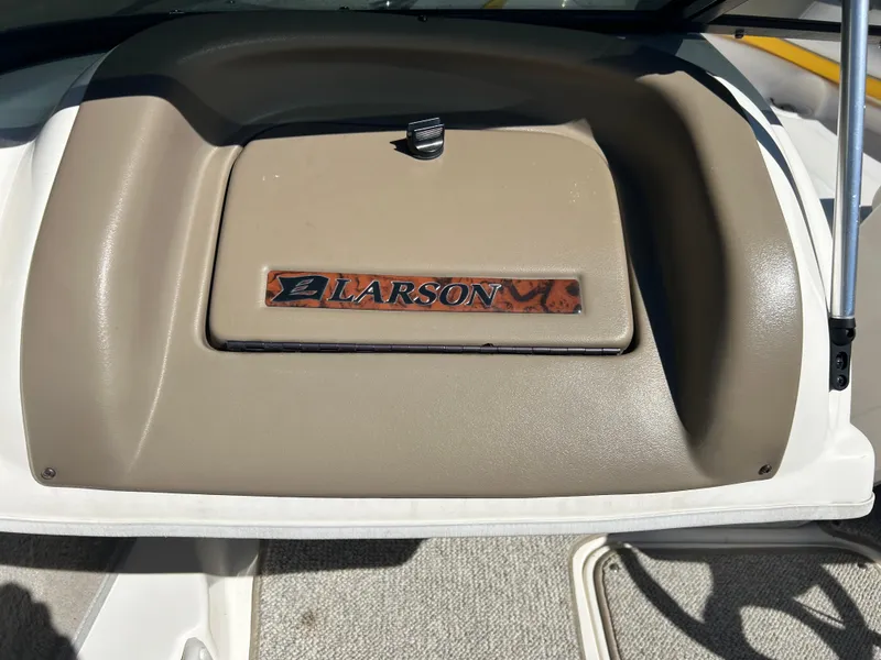 Slide: The Image of 2007 Larson 180SEI LX dashboard with logo, beige interior detail. - 8