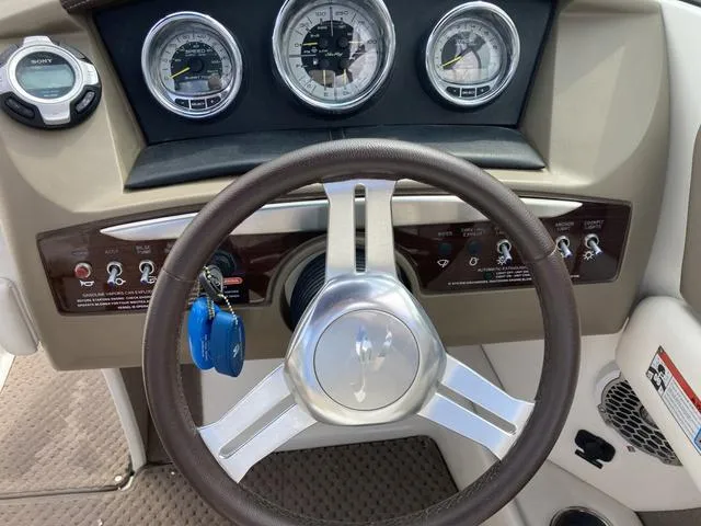 Slide: The Image of 2011 Sea Ray 230 SLX boat dashboard with steering wheel and gauges. - 15