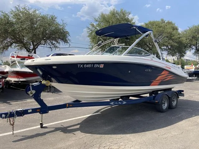 Slide: The Image of 2011 Sea Ray 230 SLX boat on a trailer in a parking lot. - 22