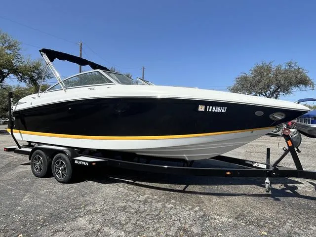 The Image of 2008 Cobalt 242 boat on a trailer, black and white exterior with yellow stripe. - 1