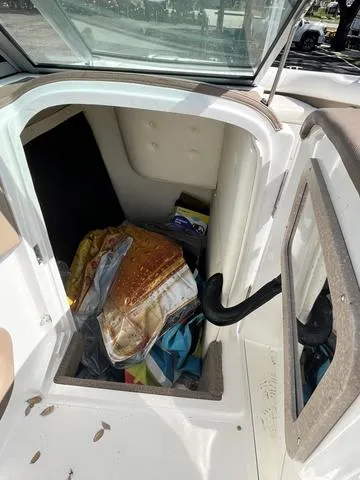 Slide: The Image of 2008 Cobalt 242 boat storage compartment with various items inside. - 25