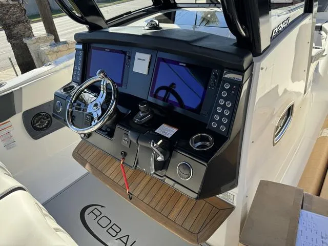 Slide: The Image of 2024 Robalo 360 boat helm with dual screens, modern controls, and sleek design. - 26