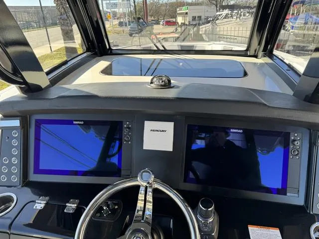 Slide: The Image of 2024 Robalo 360 boat dashboard with dual Simrad displays and Mercury controls. - 30