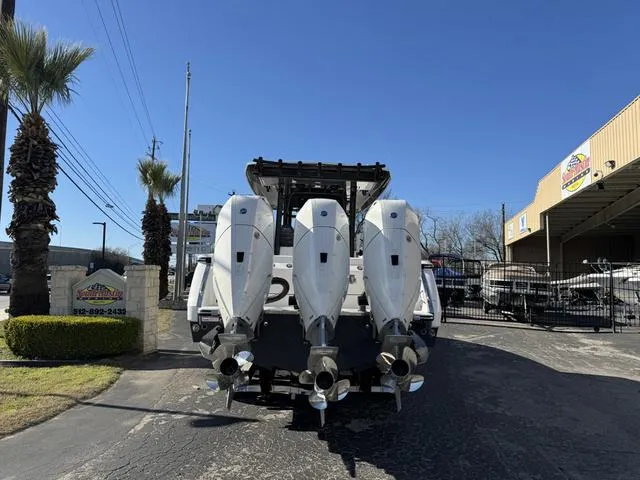 Slide: The Image of 2024 Robalo 360 boat with triple outboard engines, rear view at dealership. - 4