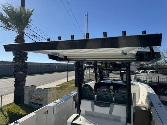 Slide: The Image of 2024 Robalo 360 boat with T-top and seating, parked near a palm tree. - 42