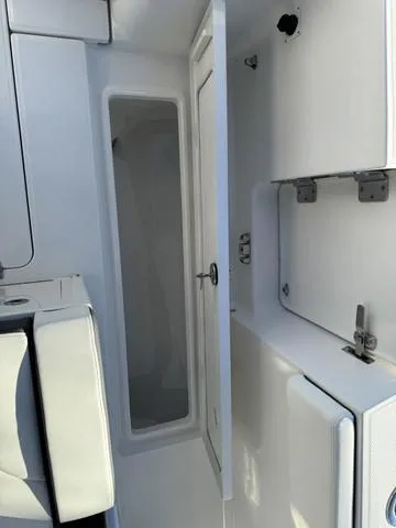 Slide: The Image of 2024 Robalo 360 boat interior storage compartment with open door. - 43