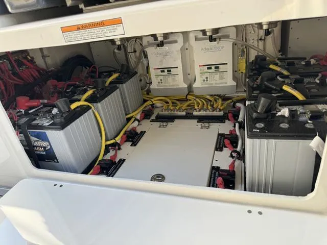 Slide: The Image of Battery compartment of 2024 Robalo 360 boat with multiple batteries and wiring. - 47