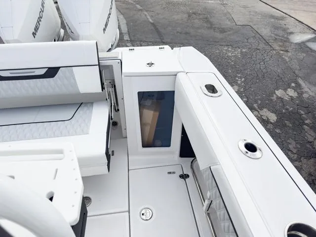 Slide: The Image of 2024 Blackfin 272 CC boat interior with white seating and storage compartments. - 13