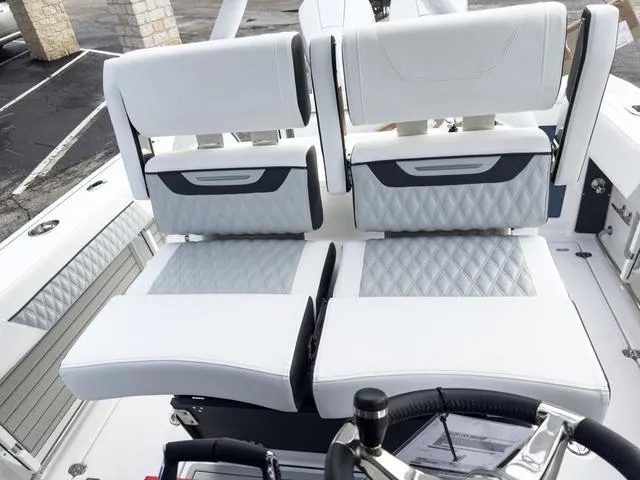 Slide: The Image of 2024 Blackfin 272 CC boat interior with white and gray diamond-stitched seats. - 25