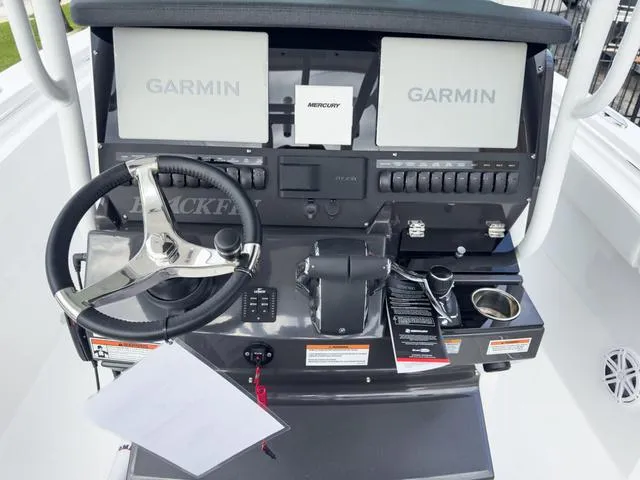 Slide: The Image of 2024 Blackfin 272 CC boat dashboard with dual Garmin displays and Mercury controls. - 29