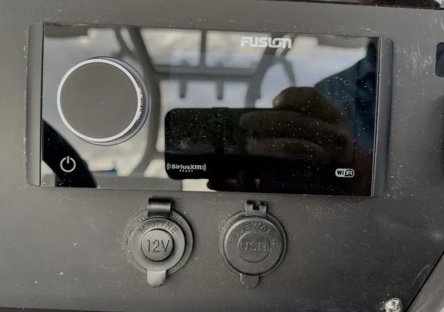 Slide: The Image of Close-up of the 2024 Blackfin 272 CC dashboard with Fusion stereo and power outlets. - 32