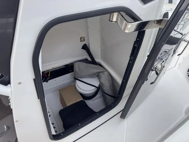 Slide: The Image of 2024 Blackfin 272 CC boat storage compartment with toilet and gear. - 41