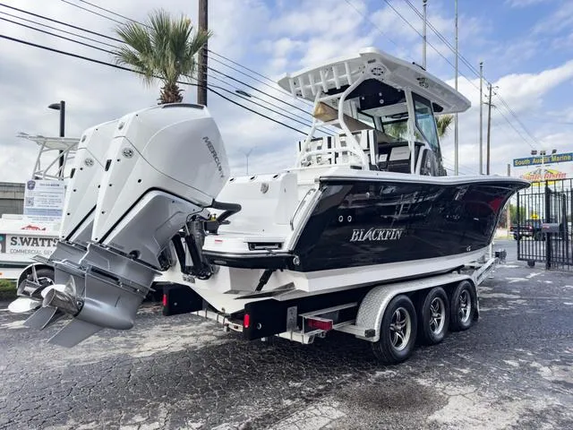 Slide: The Image of 2024 Blackfin 272 CC boat on a trailer with dual outboard engines. - 6
