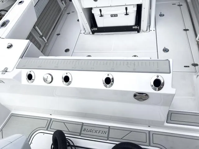 Slide: The Image of 2024 Blackfin 272 CC boat deck with rod holders and Yeti cooler. - 9