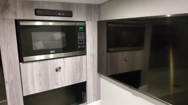 Slide: The Image of Modern kitchen area in 2023 Formula 380 SSC boat with microwave and flat-screen TV. - 18