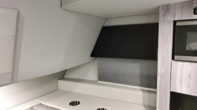 Slide: The Image of Interior of 2023 Formula 380 SSC boat with modern cabinetry and window shade. - 21