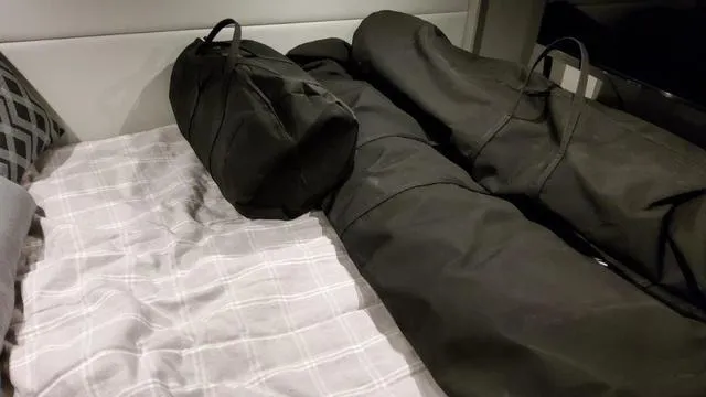 Slide: The Image of Black bags on a bed inside a 2023 Formula 380 SSC boat cabin. - 35