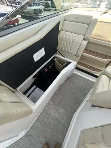 Slide: The Image of 2019 Regal 28 Express boat interior with beige seating and storage compartment. - 10