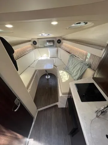 Slide: The Image of 2019 Regal 28 Express cabin interior with seating, table, and kitchenette. - 19