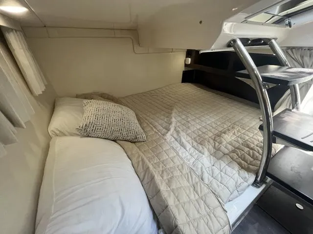 Slide: The Image of 2019 Regal 28 Express cabin bed with ladder and cozy bedding. - 20