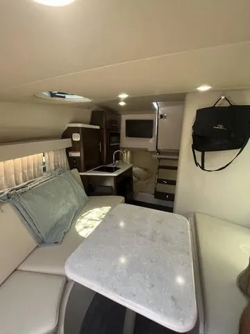Slide: The Image of Interior of 2019 Regal 28 Express boat with kitchenette, seating, and table. - 21