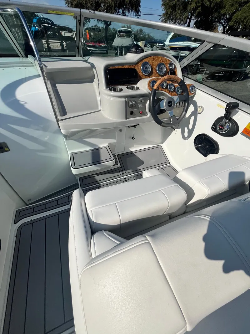 Slide: The Image of 2007 Formula Sun Sport 260 boat interior with white seating and wood-accented dashboard. - 21