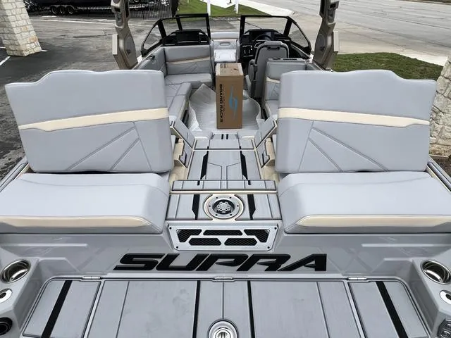 Slide: The Image of 2024 Supra SL 450 boat interior with gray and beige seating. - 16