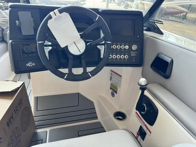 Slide: The Image of 2024 Moomba Max boat cockpit with steering wheel, control panel, and gear lever. - 7