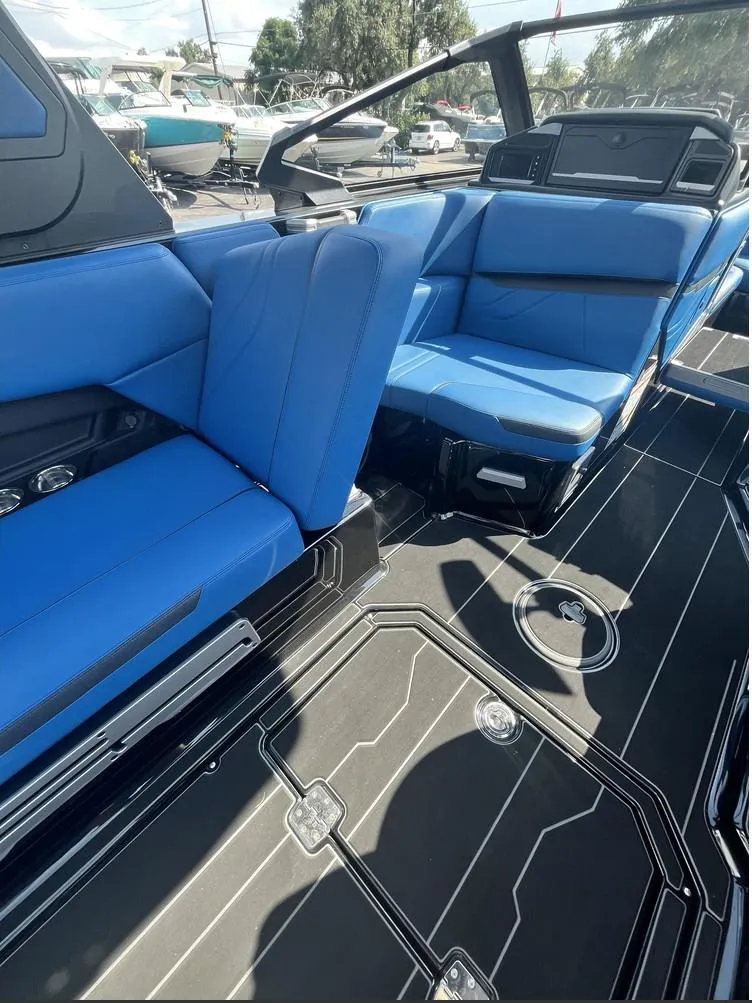 Slide: The Image of 2024 Supra SE 550 boat interior with blue seating and sleek black flooring. - 10